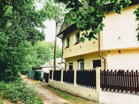 a fence in front of a house next to a building at Villa SORENTO in Mielno