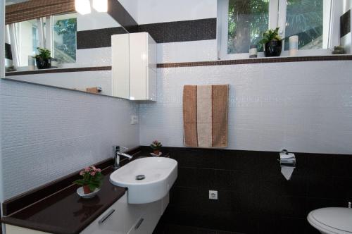een zwart-witte badkamer met een wastafel en een toilet bij Beautiful View Apt 2 in Opatija