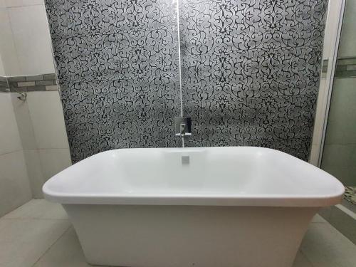 a white sink in a bathroom with a shower at Le Grant Guesthhouse in Kroonstad
