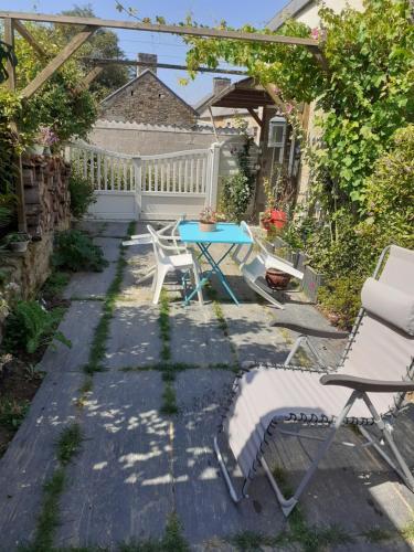 a patio with a table and chairs in a backyard at studio près du Mont Saint Michel in Champeaux