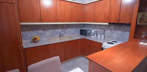 una pequeña cocina con armarios de madera y fregadero en ThirtyFive Apartment, en Aridaía