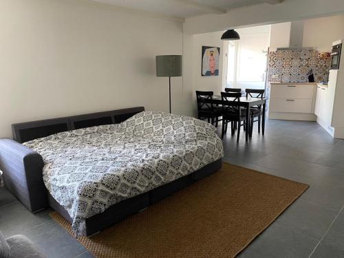 a bedroom with a bed and a kitchen and a table at Het Korenhuus in Lewedorp