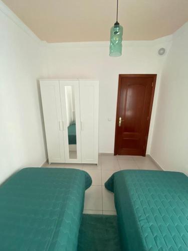 a bedroom with a green bed and a mirror at Casa Alejandro II in Tarajalejo