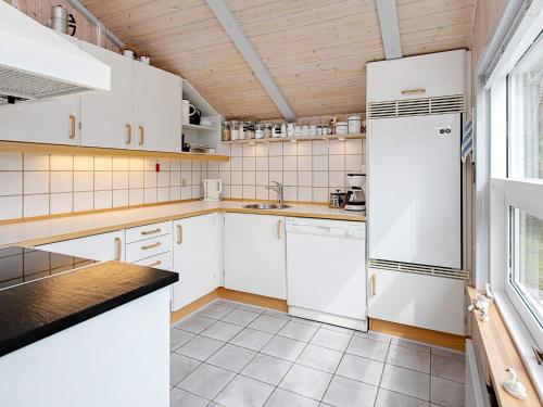 een keuken met witte kasten en een koelkast bij 8 person holiday home in Henne in Henne Strand