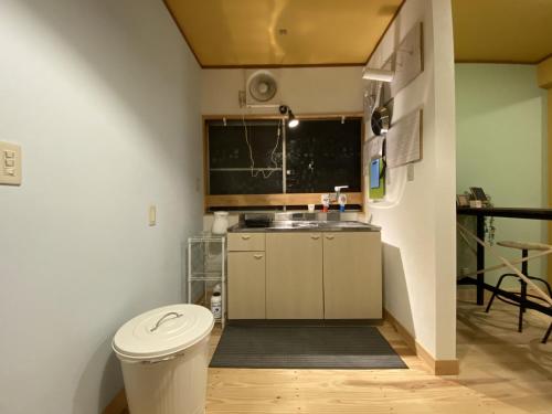a small kitchen with a toilet and a sink at mooi guesthouse 日新町 in Aizuwakamatsu