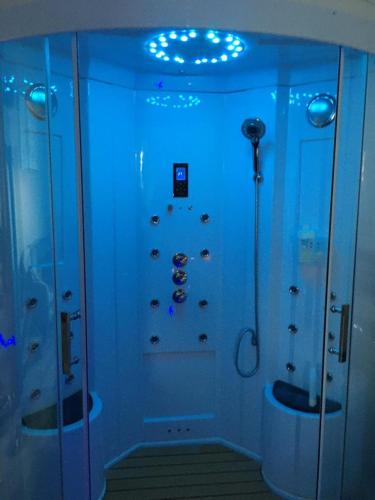 La salle de bains est pourvue d'une douche avec des lumières bleues. dans l'établissement Esprit Zen en Provence Studio Spa privatif, à Cheval-Blanc