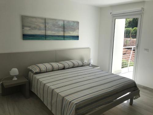 una camera da letto con un letto e un dipinto sul muro di Villa Noto-Giardino degli Allori Scopello a Balata di Baida