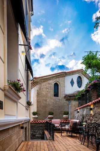 a patio with tables and chairs in front of a building at Gallery 37 Powered by ASTON in Plovdiv