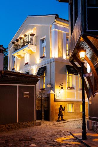 a man walking in front of a building at night at Gallery 37 Powered by ASTON in Plovdiv