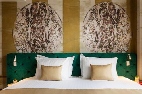 a bed with a green headboard and pillows at Gallery 37 Powered by ASTON in Plovdiv
