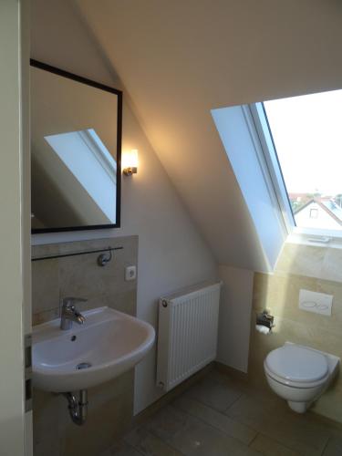 a bathroom with a sink and a toilet at Airport Park Hotel MUC in Hallbergmoos