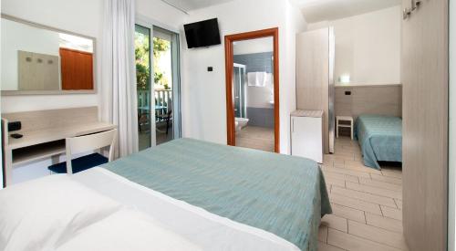a bedroom with a bed and a desk and a mirror at Residence Clipper in Giulianova