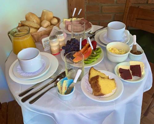 un tavolo bianco con piatti di cibo sopra di Recanto RICOROSA a Visconde De Maua