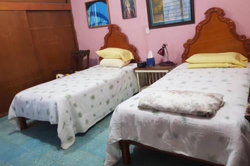 a bedroom with two beds with white sheets at Acogedora habitación en excelente ubicación in Mazatlán