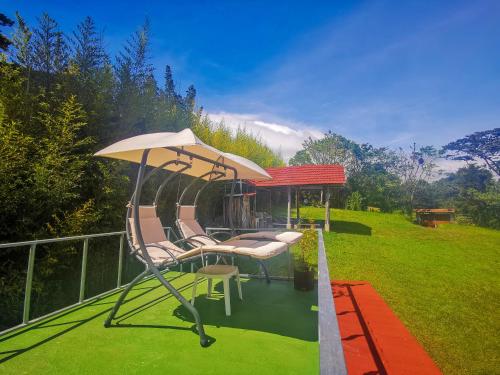 a group of chairs and an umbrella on a deck at Cabaña Mountain View in Heredia