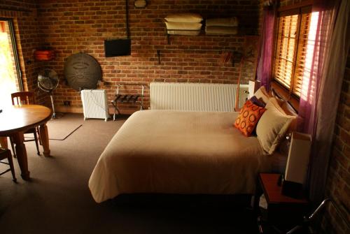 a bedroom with a large bed and a brick wall at Bundanoon @2578 in Bundanoon