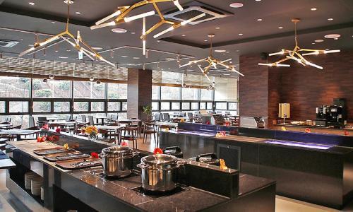 a restaurant with a counter with pots and pans at Airsky Hotel Incheon in Incheon