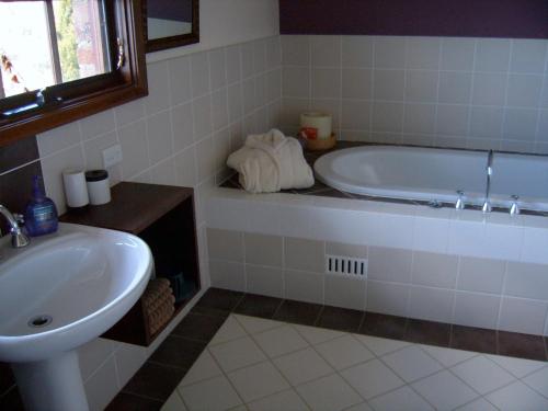 a bathroom with a bath tub and a sink at Bundanoon @2578 in Bundanoon