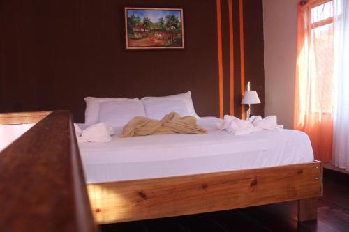 a bed with white sheets and towels on it at Quinta los volcanes in Turrialba
