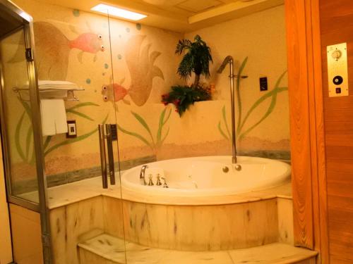 a bathroom with a bath tub in a room at Swan Lake Motel in Guishan