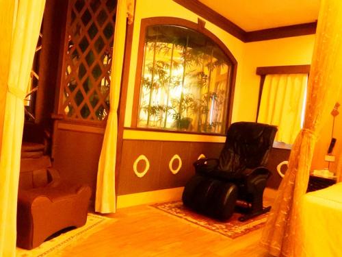 a living room with a chair and a window at Swan Lake Motel in Guishan