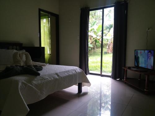 a bedroom with a bed and a sliding glass door at Los Volcanes in Turrialba