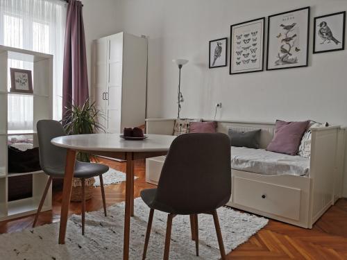 ein Schlafzimmer mit einem Tisch, Stühlen und einem Bett in der Unterkunft CityCenter Apartment TTO in Győr