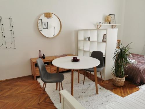Zimmer mit einem Tisch, 2 Stühlen und einem Bett in der Unterkunft CityCenter Apartment TTO in Győr