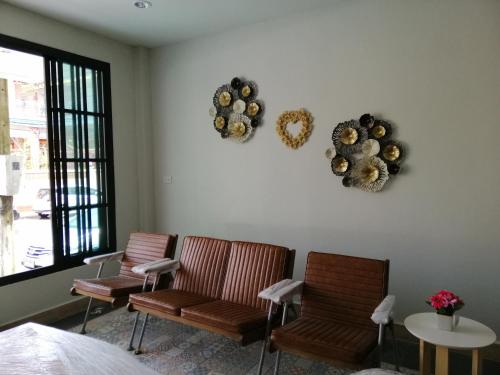 2 sillas y una mesa en una habitación con espejos en IHome Hostel Hatyai en Songkhla