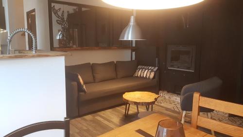 ein Wohnzimmer mit einem Sofa und einem Tisch in der Unterkunft Le Gîte de Caradoc in Paimpont