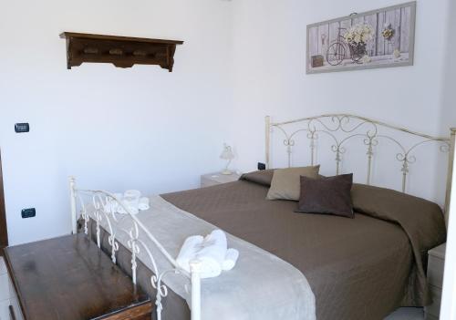 een slaapkamer met een groot bed met een metalen frame bij Casa Santa Rita / Locazione turistica Sicilia / Santa Domenica Vittoria in Santa Domenica Vittoria