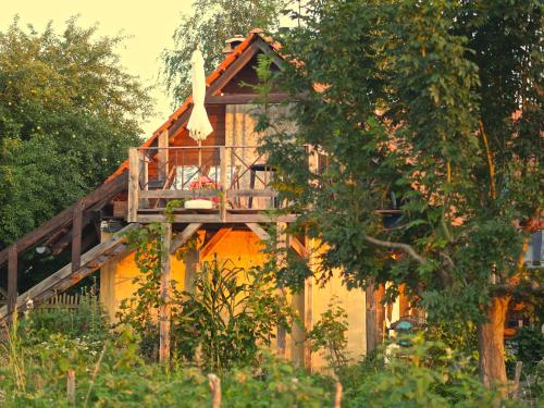Una casa en el árbol con una terraza en el costado. en Selanka Off road Hill View en Moravské Lieskové