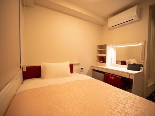 福岡市にあるホテルフロントイン福岡空港の小さなベッドルーム(ベッド1台、鏡付)