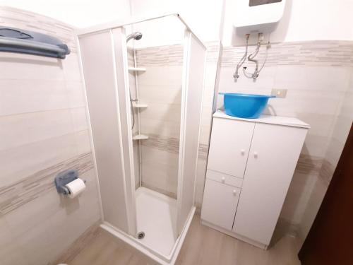 uma casa de banho branca com um chuveiro e um lavatório. em CASA VACANZE ANDREANA em Letojanni
