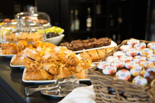 a buffet of pastries and other pastries on a table at GoTì Hotel in Nago-Torbole