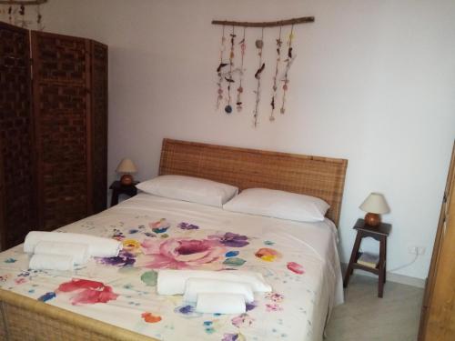 ein Schlafzimmer mit einem Bett mit Blumen darauf in der Unterkunft Sweet Home by Giò in Mola di Bari