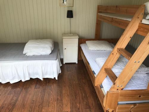 2 Etagenbetten in einem Zimmer mit Holzböden in der Unterkunft Villa Lavendel in Borgholm