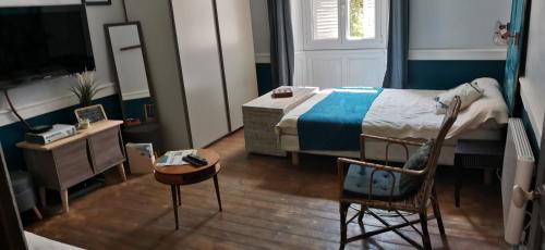 1 dormitorio con 1 cama, 1 mesa y 1 silla en Charmant Studio au calme à 5 min du centre ville, en Saint-Claude