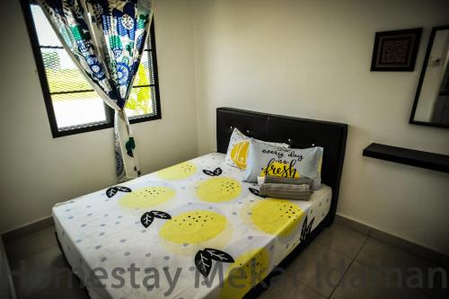 een bed met gele en witte lakens en een raam bij homestay mekar idaman in Kepala Batas