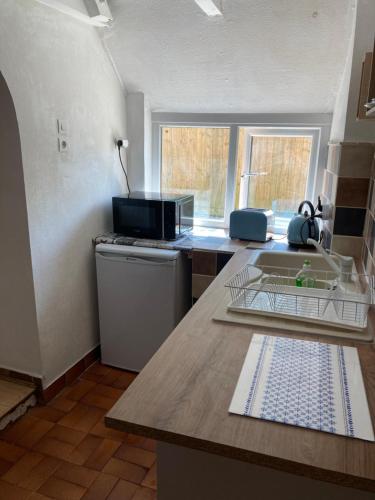 - une cuisine avec un comptoir et un lave-vaisselle dans l'établissement La Vieille Crêperie de Mangouëro, à Cléguérec