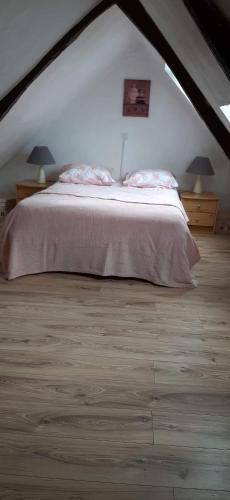 une chambre avec un grand lit dans un grenier dans l'établissement La Vieille Crêperie de Mangouëro, à Cléguérec