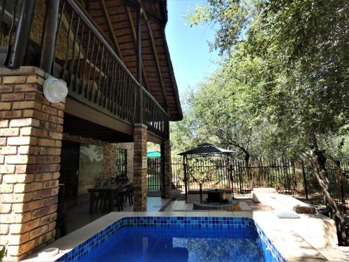a swimming pool in the backyard of a house at Weltevrede Lodge - Self Catering Houses in Marloth Park