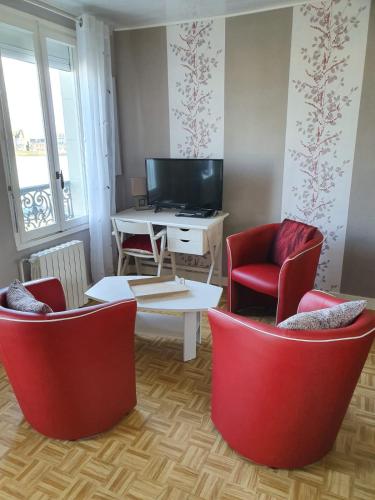 un salon avec des chaises rouges et une table dans l'établissement 180° VUE MER, au Tréport