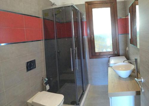 e bagno con doccia, servizi igienici e lavandino. di A.I.R. Badesi Borgo di Mare a Badesi