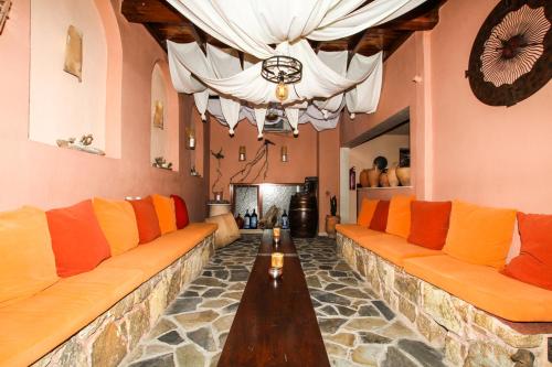 a large living room with orange and yellow couches at Xenonas Apollon in Sarti