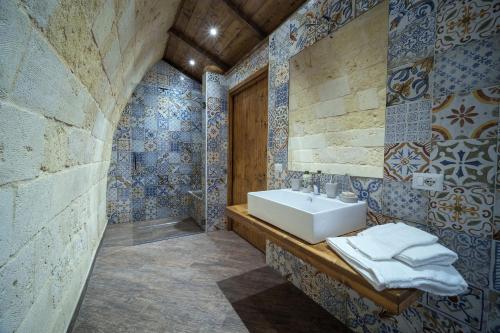 bagno con lavandino e piastrelle bianche e blu di ROBERTO's Guest House ad Andria