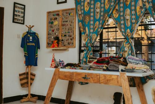 a room with a table with a jersey on a wall at Mambo Arusha Hostel in Arusha