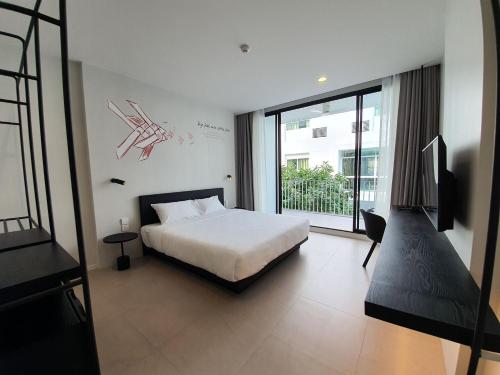 a bedroom with a bed and a large window at CHERN Bangkok in Bangkok