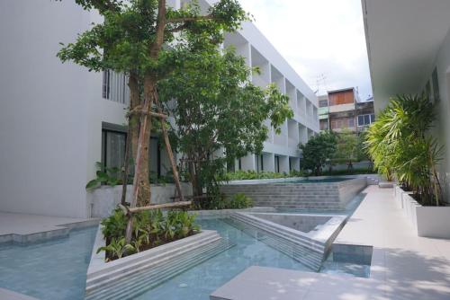 a courtyard of a building with a tree and stairs at CHERN Bangkok in Bangkok