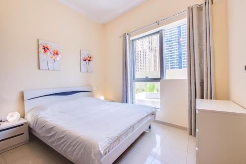 Schlafzimmer mit einem Bett und einem Fenster in der Unterkunft Bay Central apartment with awesome Marina view in Dubai